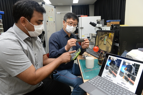 ETRI 연구진이 개발한 복합소재와 이를 기반으로 만든 내방사선 압력-온도 복합센서를 장갑에 적용하여 시연하고 있는 모습. (왼쪽부터 슈브라몬달 UST 학생연구원, 최춘기 책임연구원)